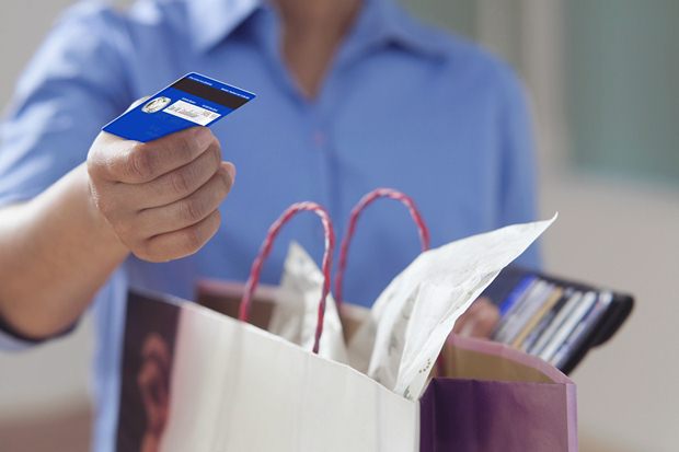 Close up of hand offering credit card