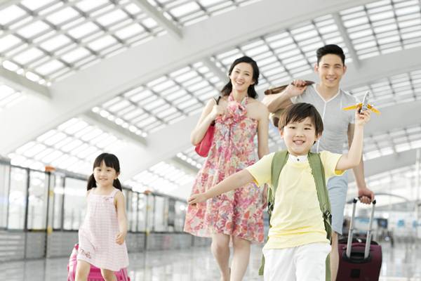 25 May 2013 --- Happy family with luggage at the airport --- Image by © Blue Jean Images/Corbis