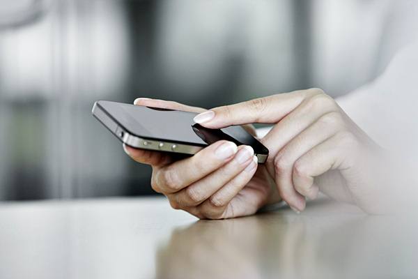 Business man texting on his mobile --- Image by © John Smith/Corbis